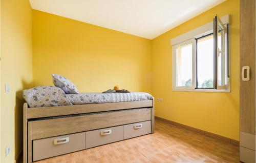 a bedroom with yellow walls and a bed with a window at Amazing Home In Candamo With Kitchen in Candamo
