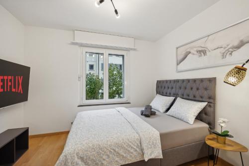 a bedroom with a bed and a window at Pearlstay - City Center Workplace Balcony Washer in Winterthur