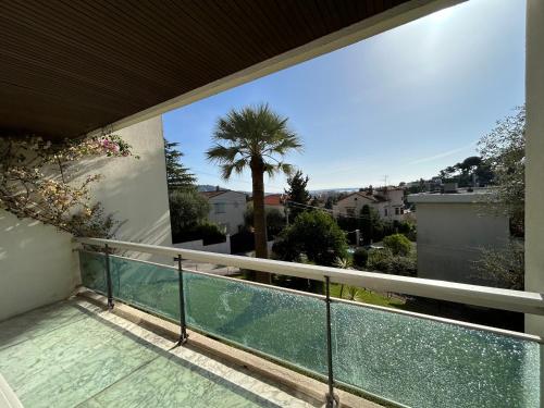 d'un balcon avec vue sur un palmier. dans l'établissement Sea view flat with car park boarder Cannes, au Cannet