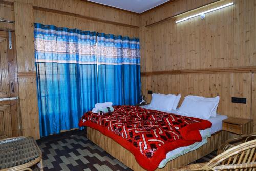 a bedroom with a large bed with a blue curtain at Sunset Lagoon Dalhousie in Dalhousie