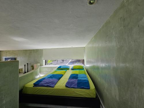 a bed in a small room with a window at La Ranita 2 EMPIREO in La Asomada