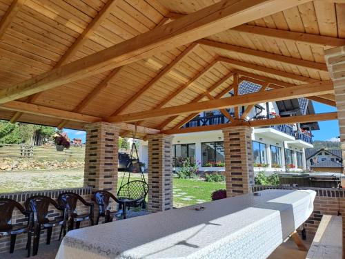 a wooden pavilion with a table and chairs at Conacul Munții Bucovinei in Câmpulung Moldovenesc