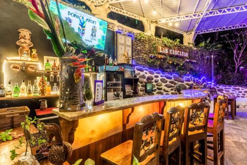 a bar in a restaurant with purple lights at Boutique Hotel Las Cascadas in Manuel Antonio