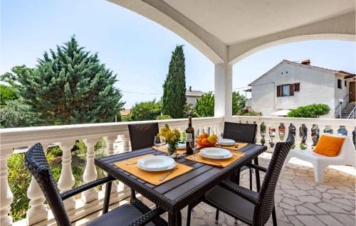 a table and chairs on a balcony with a table at Cozy Apartment In Krk With Wifi in Krk