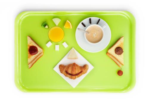 a green tray with a plate of food and a cup of coffee at ibis budget L'Isle Adam in LʼIsle-Adam