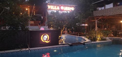 a swimming pool in front of a hotel at night at Bunaken Guesthouse The Queen's in Bunaken