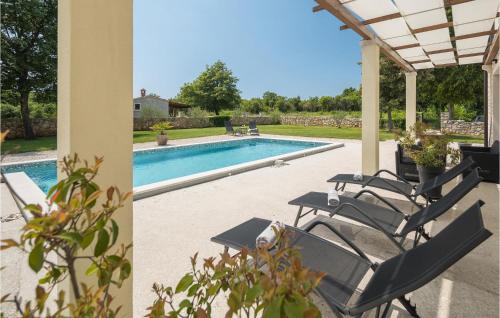 a group of chairs sitting next to a swimming pool at Stunning Home In Bale With Wifi in Bale