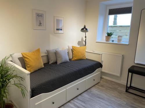 un sofá con almohadas amarillas en una habitación en Ferienwohnung Watt'n Weitblick, en Simonsberg