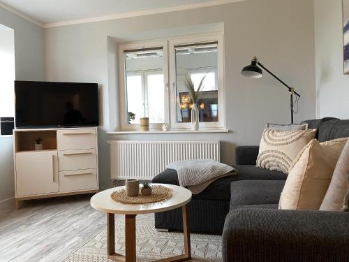 Una sala de estar con un sofá y un televisor. en Ferienwohnung Watt'n Weitblick, en Simonsberg