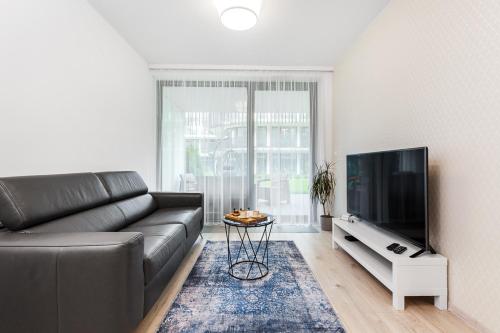 Una sala de estar con un sofá y un televisor de pantalla plana. en Stegna Amber Apartment, en Stegna
