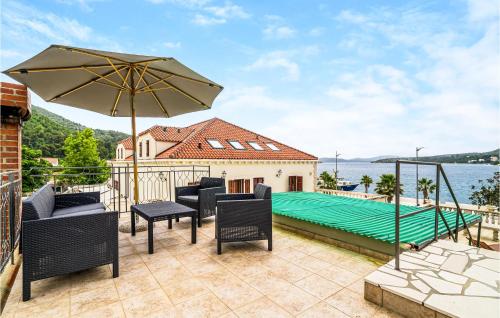 a patio with an umbrella and a swimming pool at Amazing Home In Slano With Kitchen in Slano