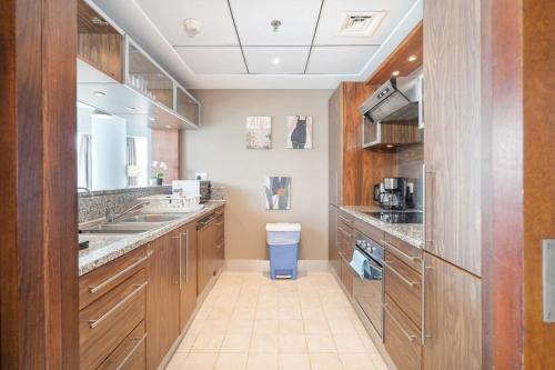 a large kitchen with wooden cabinets and a sink at 2 Bedroom Apartment full Marina View in Dubai