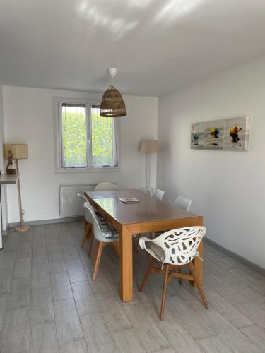 a dining room with a wooden table and chairs at Ty Bihan in Crozon