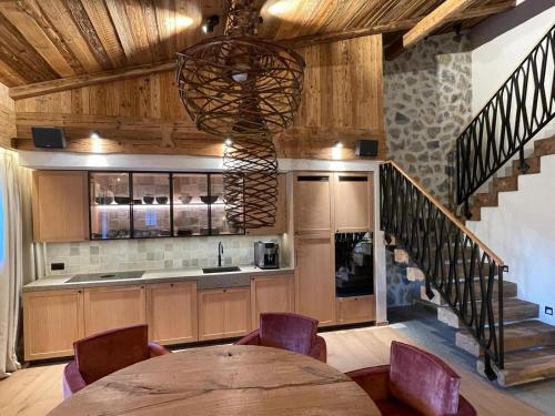 a kitchen with wooden cabinets and a table and a staircase at BelArosa Chalet - the luxury hideaway in the Swiss Alps in Arosa