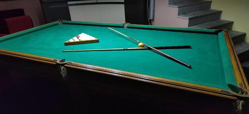 a green pool table with a piece of cake and chopsticks at Areg Hotel in Yerevan