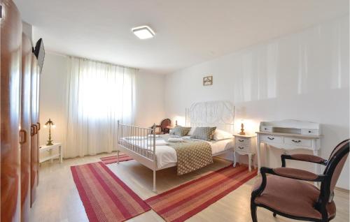 a white bedroom with a bed and a desk at Nice Home In Zrnovnica-Split With Sauna in Cista Provo