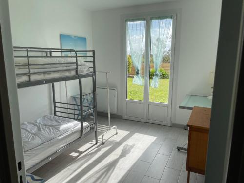 a room with two bunk beds and a window at Ty Bihan in Crozon