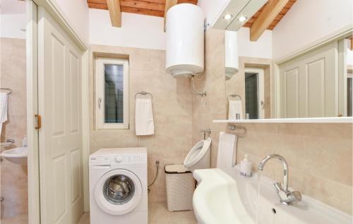 a bathroom with a washing machine and a sink at Nice Home In Zrnovnica-Split With Sauna in Cista Provo