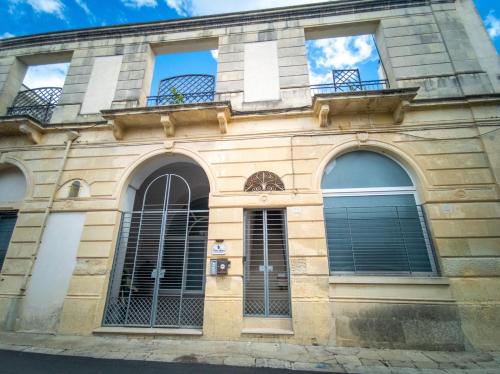 an old building with windows and a blue sky at Percebes Exclusive B&B in Cutrofiano
