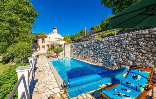 a swimming pool next to a stone wall at Nice Home In Moscenice With Wifi in Mošćenice