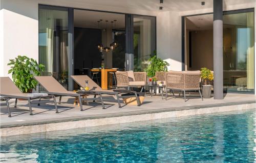 a group of chairs and a table next to a swimming pool at Nice Home In Pula With Kitchen in Štinjan
