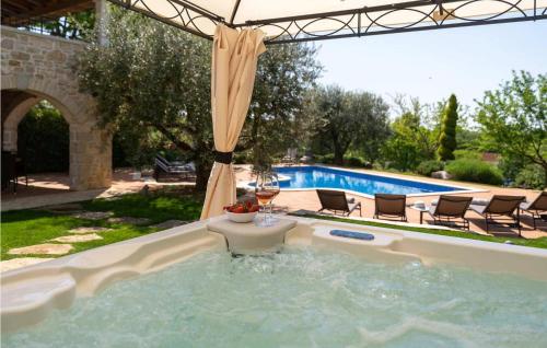 une piscine avec des chaises et un verre de vin dans une piscine dans l'établissement Villa Pilato, à Vižinada