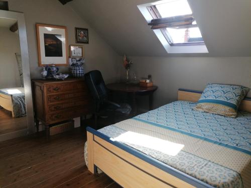 une chambre avec un lit, un bureau et une chaise dans l'établissement Maison sansonnette, à Guérigny