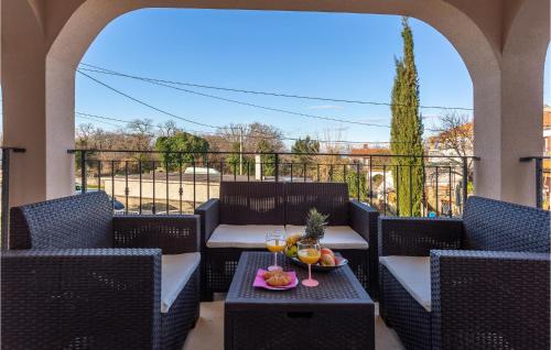 a table with two glasses of wine and fruit on a balcony at Lovely Home In Rasopasno With Wifi in Rasopasno