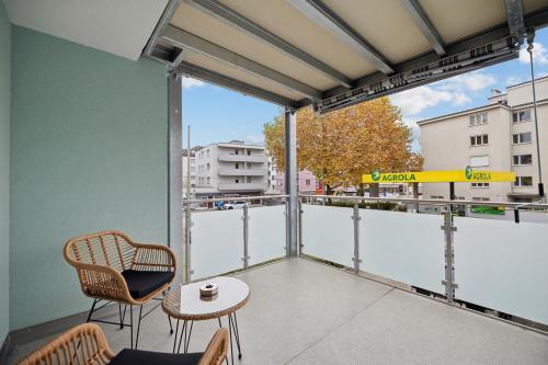 a balcony with a table and chairs and a large window at Pearlstay - City Center Workplace Balcony Washer in Winterthur