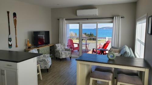 a kitchen and living room with a view of the ocean at Ocean Breeze in Ingonish Beach