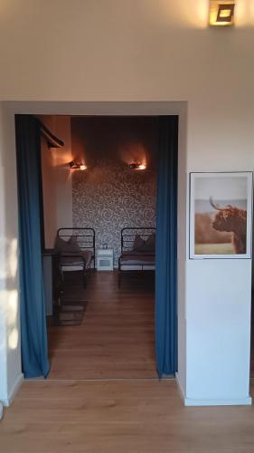 a hallway with blue curtains and a room with a couch at Meisterhaus Apartment 2 in Glauchau