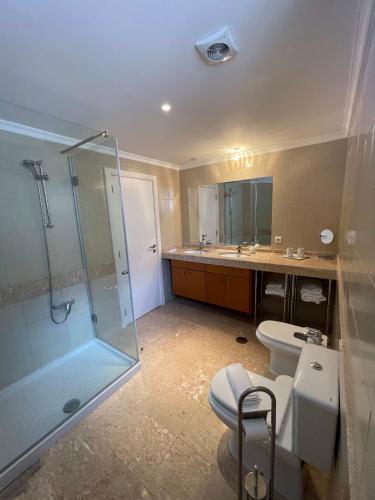a bathroom with a shower and a toilet and a sink at In Town View in Funchal