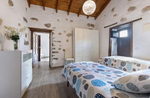 a bedroom with two beds and a television in it at Casa Doña Carmen in Betancuría
