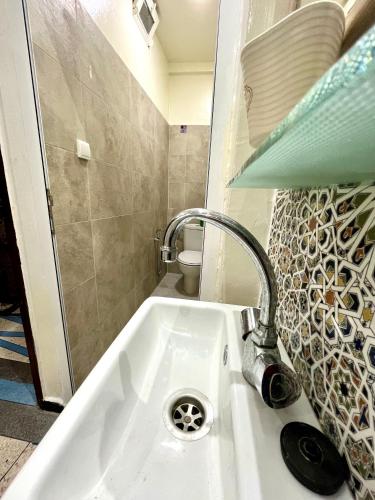 a bathroom sink with a faucet and a toilet at Agadir House 2 in Agadir