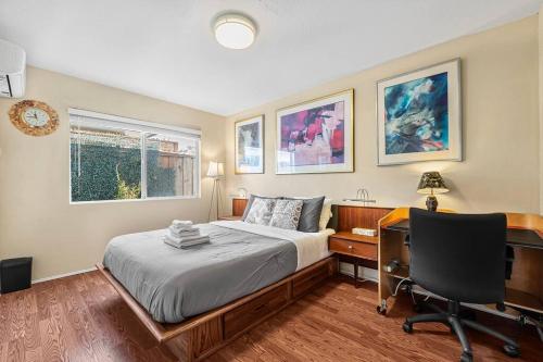 ein Schlafzimmer mit einem Bett, einem Schreibtisch und einem Computer in der Unterkunft Beauty Supplies 3Br house for Family in Fremont in Fremont
