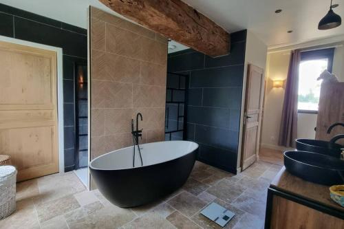 une grande salle de bain avec une baignoire et un lavabo dans l'établissement La Maison As de Cœur, 5 suites, 10 personnes, à Allonnes