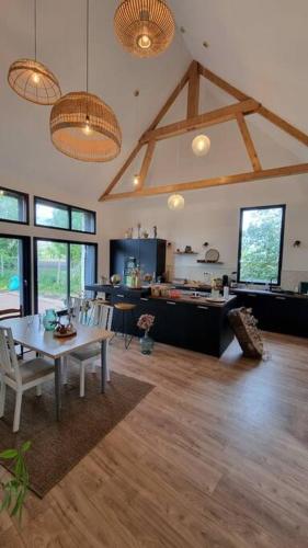 un salon avec une table et une cuisine dans l'établissement La Maison As de Cœur, 5 suites, 10 personnes, à Allonnes