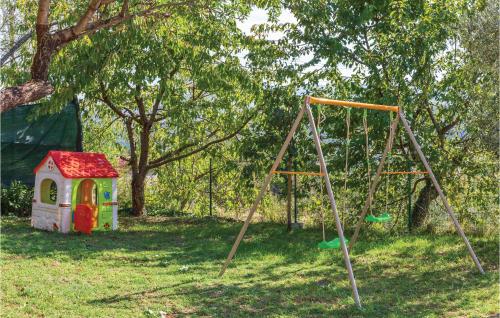 a swing set and a dog house in a yard at Holiday Home Vojnic Sinjski 11 in Vojnić Sinjski