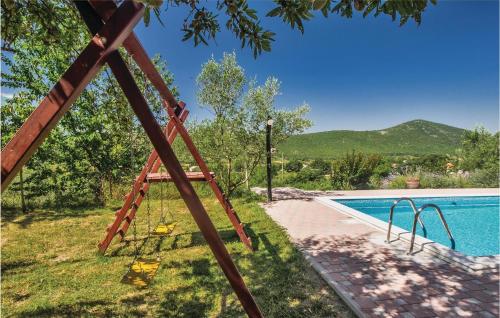 a swing set next to a swimming pool at Holiday Home Vojnic Sinjski 11 in Vojnić Sinjski