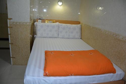 uma cama num quarto com um cobertor laranja em Everest Base Camp Hostel em Hong Kong
