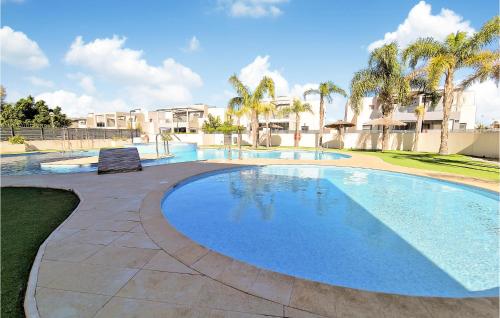 a large swimming pool in a resort with palm trees at 3 Bedroom Nice Home In Torrevieja in Torrevieja