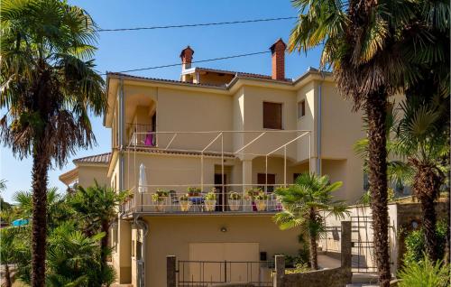 a house with palm trees in front of it at 1 Bedroom Stunning Apartment In Lovran in Lovran
