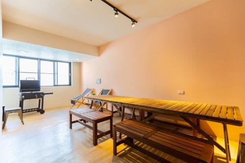 a room with a table and benches and a piano at Tainan Little Day in Tainan