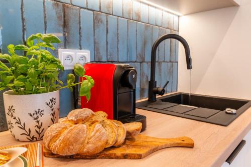 a kitchen counter with bread on a cutting board and a sink at FoRest Longinówka - las, jezioro, parking, Netflix i Prime, TV55" in Brodnica