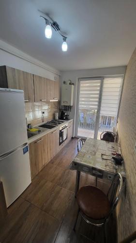 a kitchen with a table and a white refrigerator at Budget Stay Florești in Floreşti