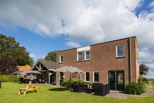 a brick building with a picnic table in the yard at Bij de Buurman in Dalmsholte