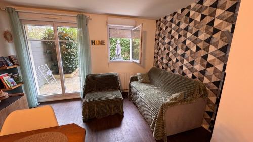 a living room with a couch and a window at Appartement T2 Rez de jardin - Disneyland Paris 6 min in Bussy-Saint-Georges