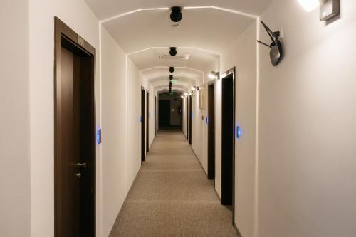 a hallway with white walls and a long aisle with white ceilings at Hotel Gradche in Kochani