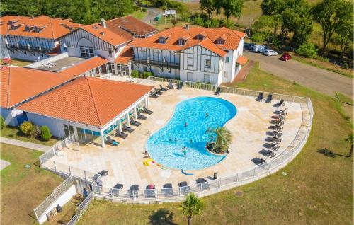 an aerial view of a large swimming pool in front of a house at 2 Bedroom Pet Friendly Apartment In Cassen in Cassen