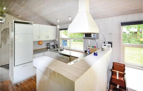 a kitchen with white cabinets and a white refrigerator at Lovely Home In Glesborg With Wifi in Fjellerup
